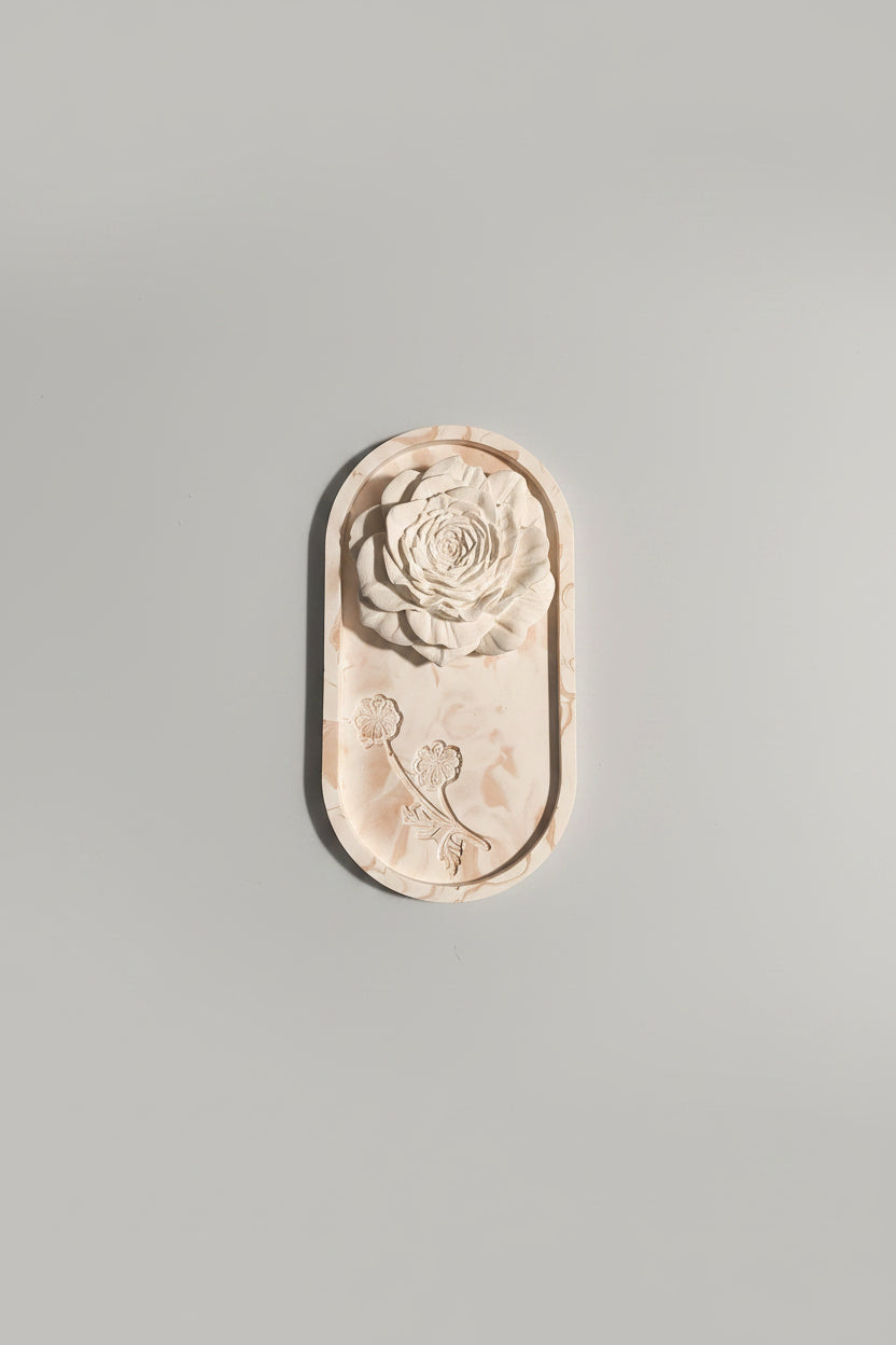 An unglazed ceramic relief mold featuring a carved rose design.