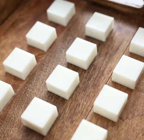 Small white square blocks arranged on a wooden surface.