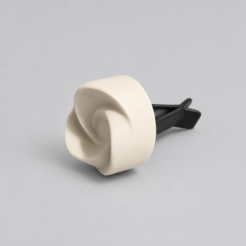 A small white swirl shaped object with a black stem.